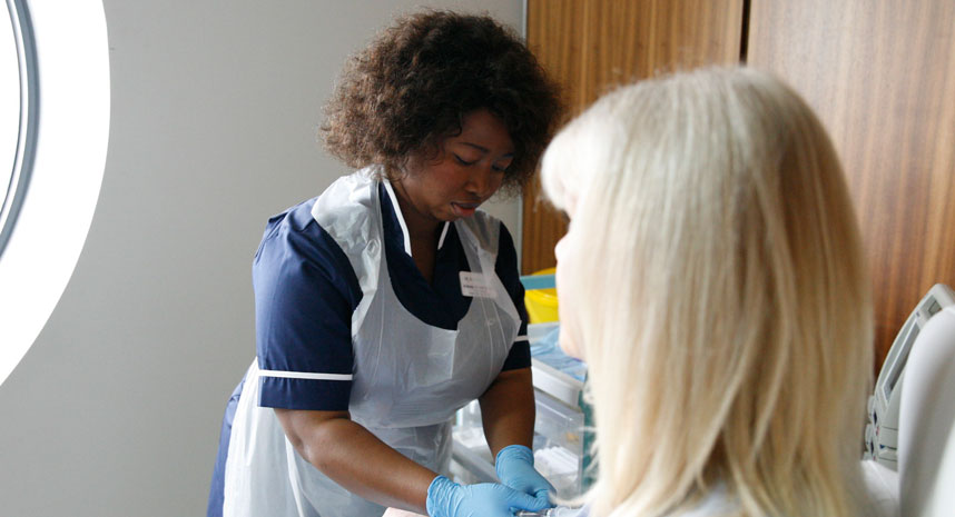 Nurse setting patient up on chemotherapy machine
